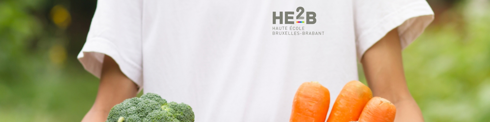 Étudiant avec des fruits et légumes pour l'Épicerie Partagée HE2B